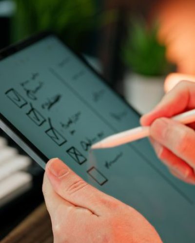 pexels photo 33222053 33222053 Close-up of hands using a stylus to write on a digital checklist, enhancing productivity.